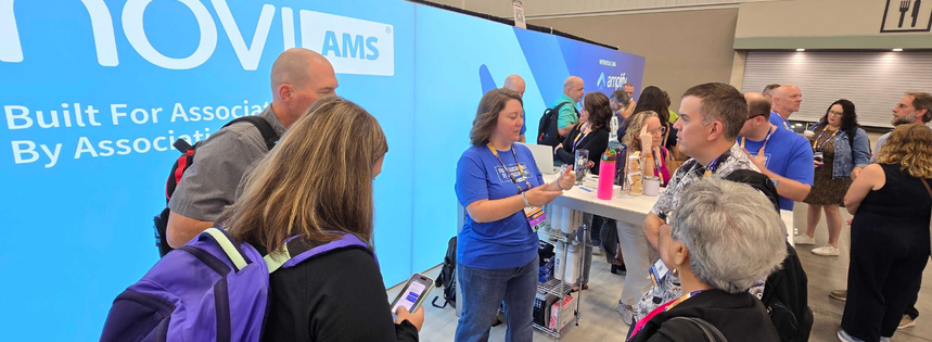 Attendees gather and talk at the Novi AMS booth at ASAE 2026