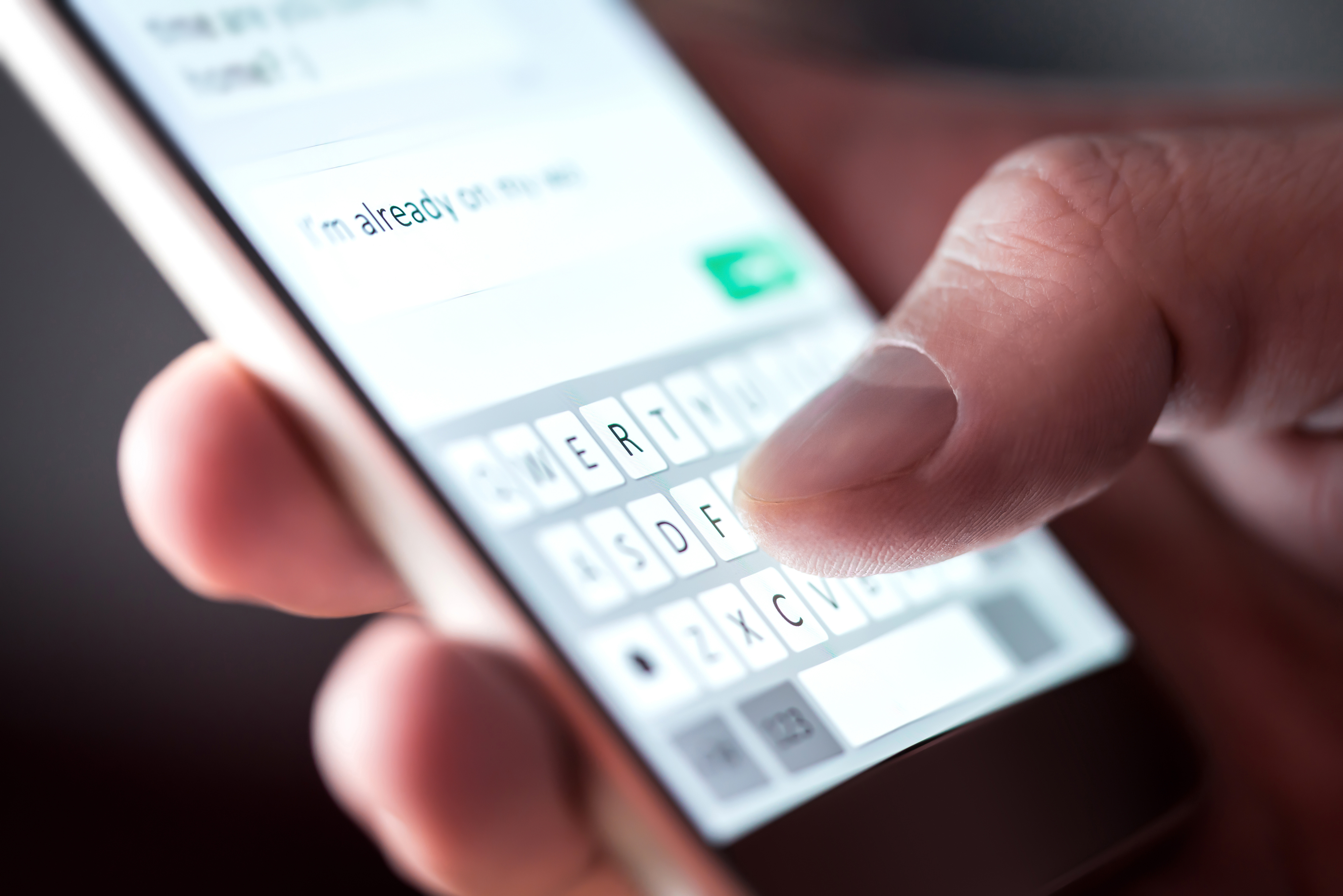 A close up of a hand typing a text on a smart phone