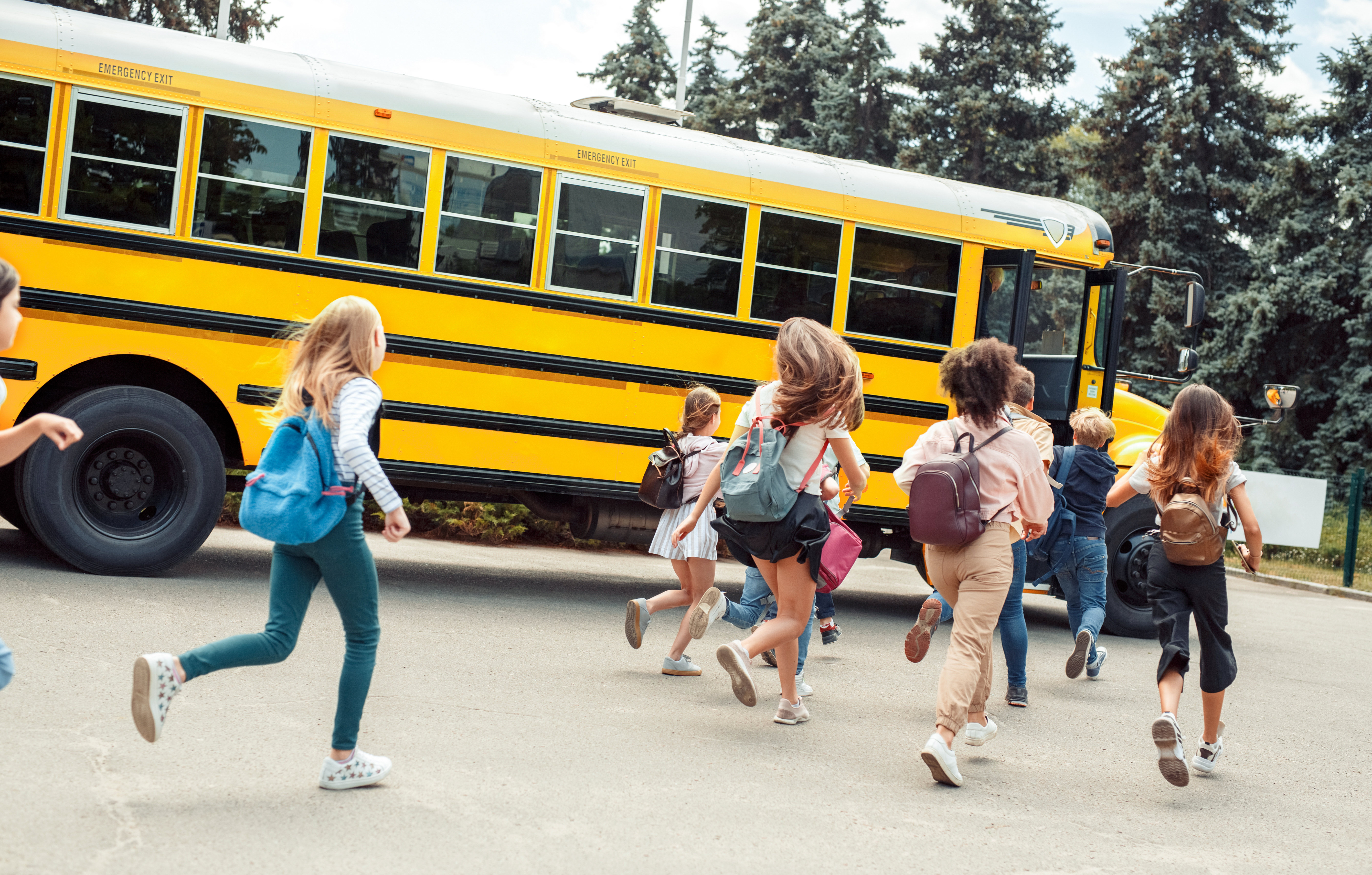 Pictured above: a group of school children run to a school bus.