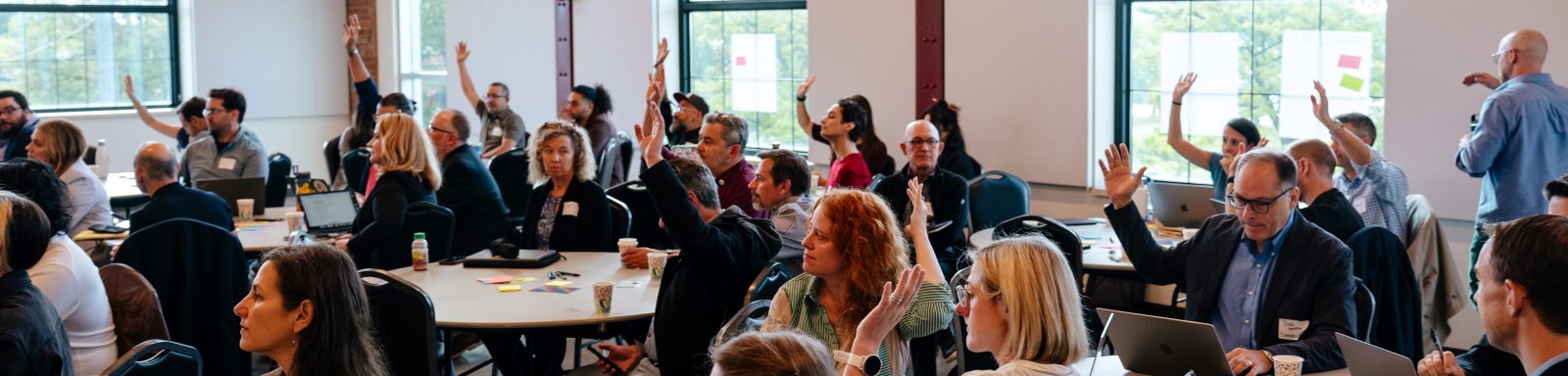 People at a program raising hands