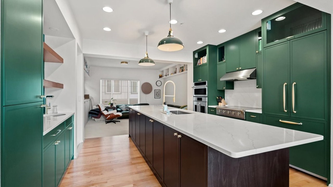 Kitchen remodel in Redmond, WA with green cabinetry and walnut island by Higgason Homes