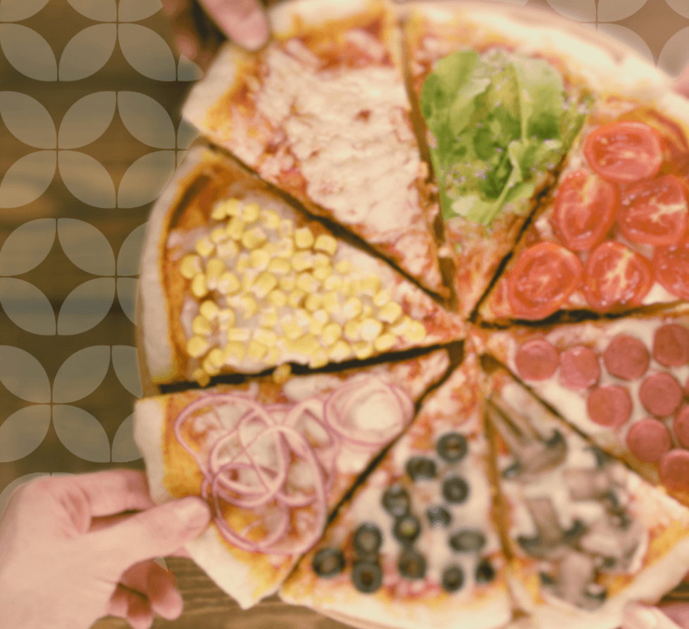 A pizza with eight distinct toppings: cheese, lettuce, tomato, pepperoni, mushroom, olives, red onion, and corn. Four hands grab one slice each, conveying sharing.