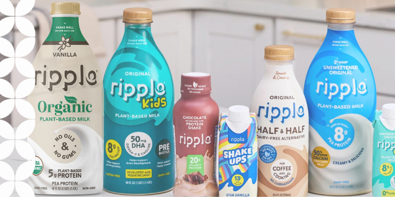 Array of Ripple plant-based milk products on a kitchen counter, featuring various flavors and types, including organic, kids, protein shakes, and half & half.