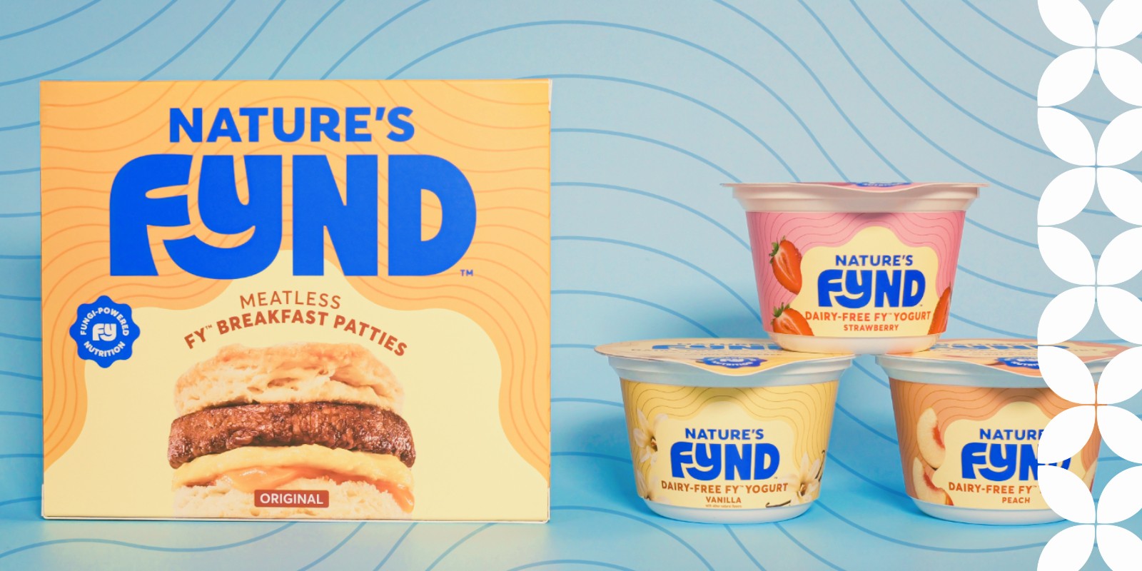 A box of Nature's Fynd "Meatless Fy Breakfast Patties" displaying a breakfast sandwich next to a stack of three containers of "Dairy-Free Fy Yogurt" in strawberry, vanilla, and peach flavors. A light blue background with faint wavy lines is visible, and a white geometric pattern frames the right edge.