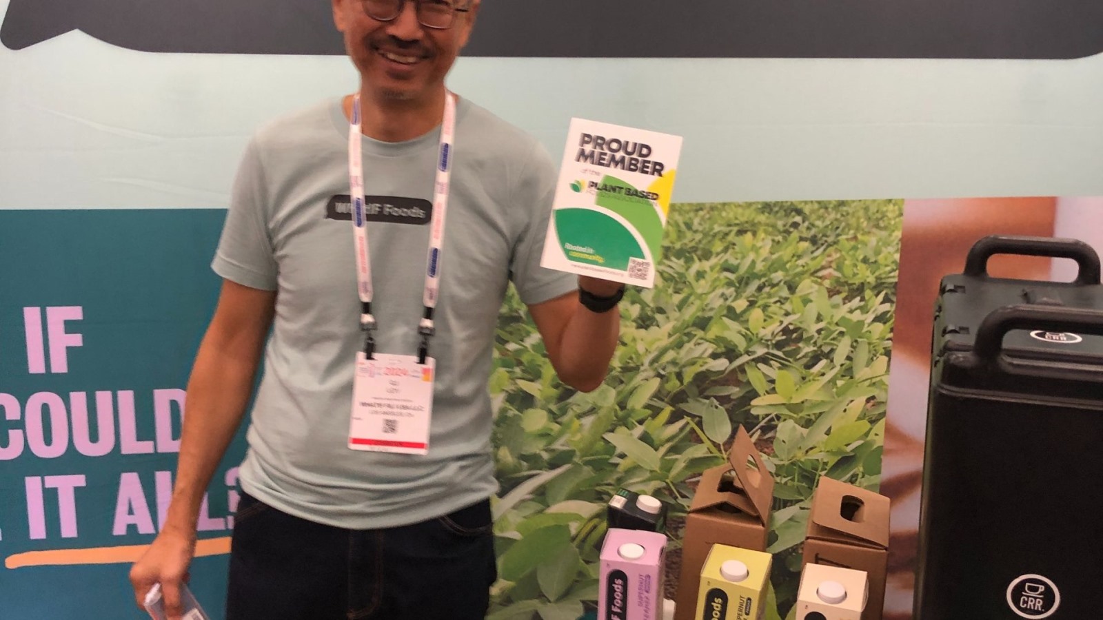 PBFA Member holding up a proud member sign at a trade show
