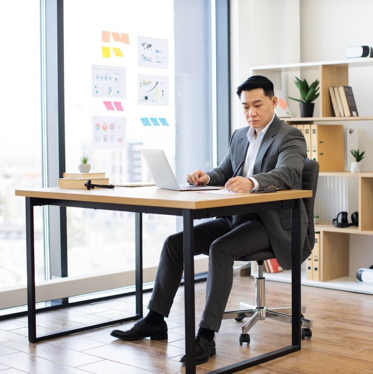 Asian businessman in modern office working on laptop