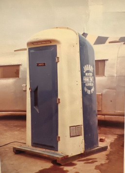 A blue and white Johnny On The Spot Portable Sanitation unit