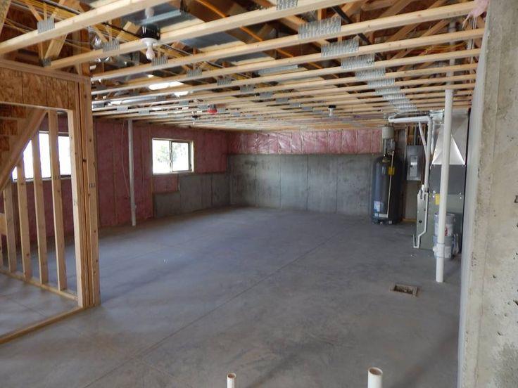 Unfinished residential basement with exposed floor framing overhead
