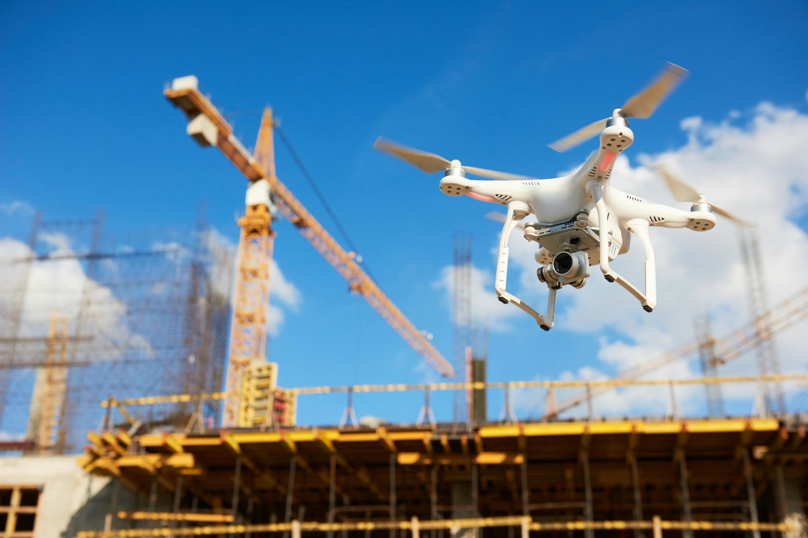 Drone flying in construnction area with crane in background