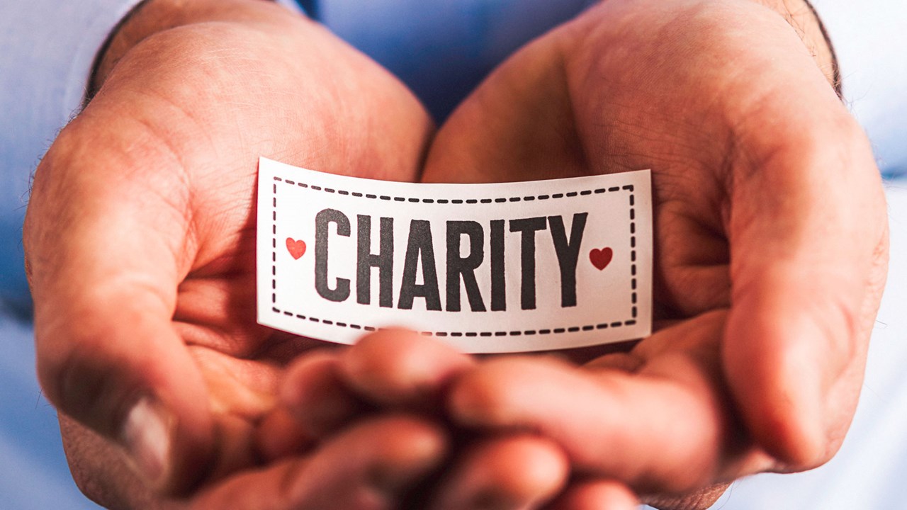 Hands holding charity sign symbolizing nonprofit state registration and renewal services