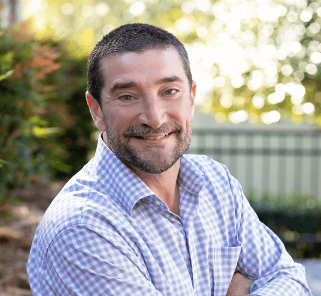 A person with a beard and mustache smilingAI-generated content may be incorrect.