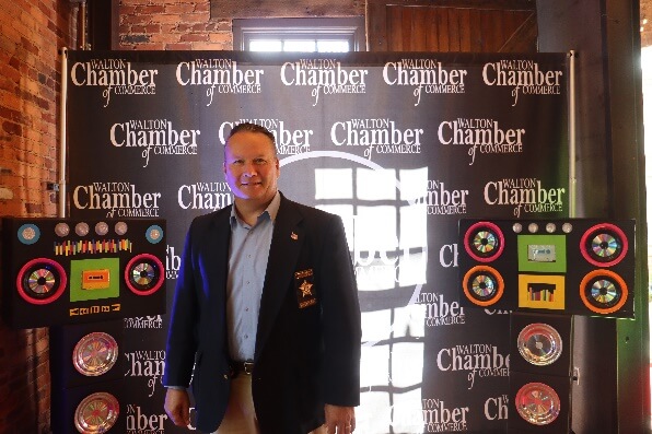 A person standing in front of a black bannerAI-generated content may be incorrect.