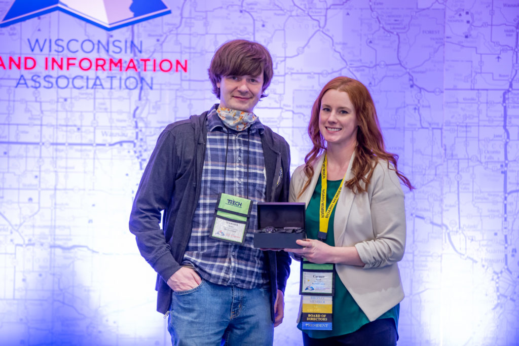 Brannick Beatse receives an award from President Carmen Novak